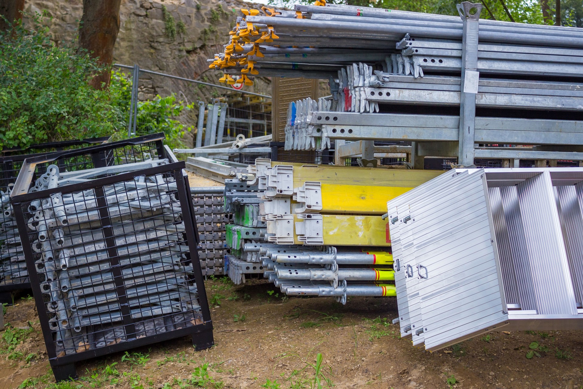 Pali e staffe per ponteggi impilati in un cortile. Ponteggio a telaio giapponese.